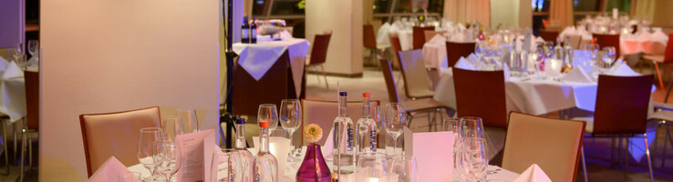 Elegantes Hotelrestaurant mit festlich gedeckten Tischen, weißen Tischdecken und sanfter Beleuchtung im ATLANTIC Hotel Sail City.