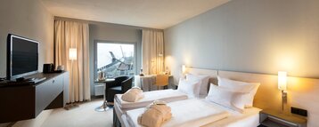 Interior view of the Business Pluss Room in the ATLANTIC Hotel Universum Bremen with a double bed, flatscreen TV and cozy equipment