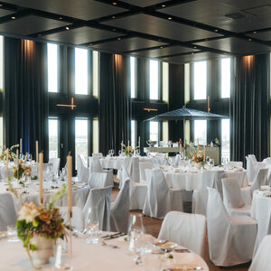 Eleganter Bankettsaal im ATLANTIC Hotel Heidelberg mit gedeckten Tischen und großen Fenstern.
