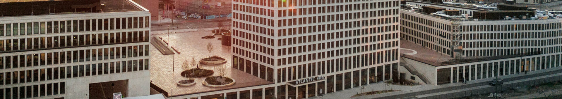 Modernes Hotelgebäude bei Sonnenuntergang, umgeben von städtischer Architektur in Heidelberg.