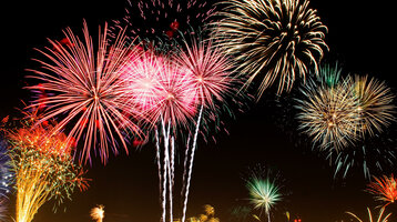 Buntes Feuerwerk erleuchtet den Nachthimmel über Münster, festliche Atmosphäre beim ATLANTIC Hotel.