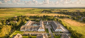 Aerial view of the Severin*s Resort & Spa on Sylt, surrounded by green fields and idyllic countryside.