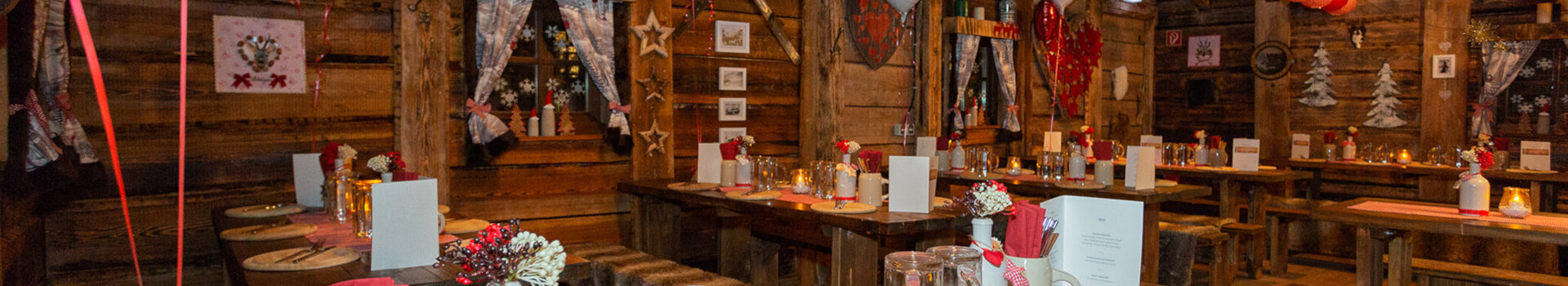Cozy, rustic restaurant with wooden tables, decorated with red lanterns and heart motifs at the ATLANTIC Grand Hotel Bremen.