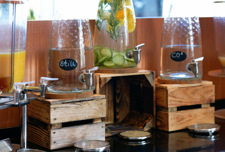 Drinks dispenser with still water, lemon water and sparkling water at the ATLANTIC Hotel Galopprennbahn Bremen.