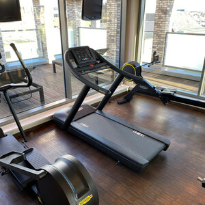 Fitness studio at the ATLANTIC Hotel Kiel Fitness room at the ATLANTIC Hotel Kiel with treadmill, rowing machine and dumbbells in front of large windows.