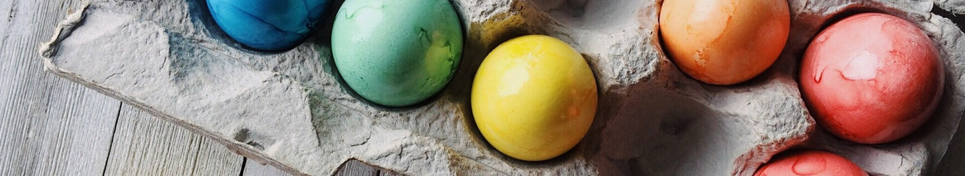 ATLANTIC Hotel Universum Easter Brunch Colorful Easter eggs in an egg carton on a wooden base.