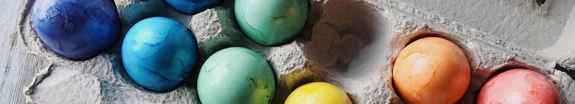 ATLANTIC Hotel Universum Osterbrunch Bunte Ostereier in einem Eierkarton auf Holzuntergrund.