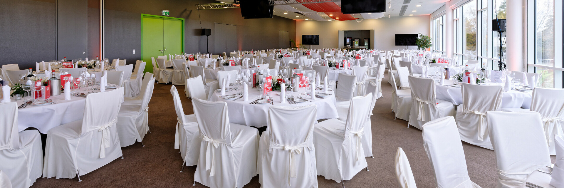 Großer, elegant dekorierter Bankettsaal mit weiß gedeckten Tischen und Stühlen im ATLANTIC Hotel Galopprennbahn.