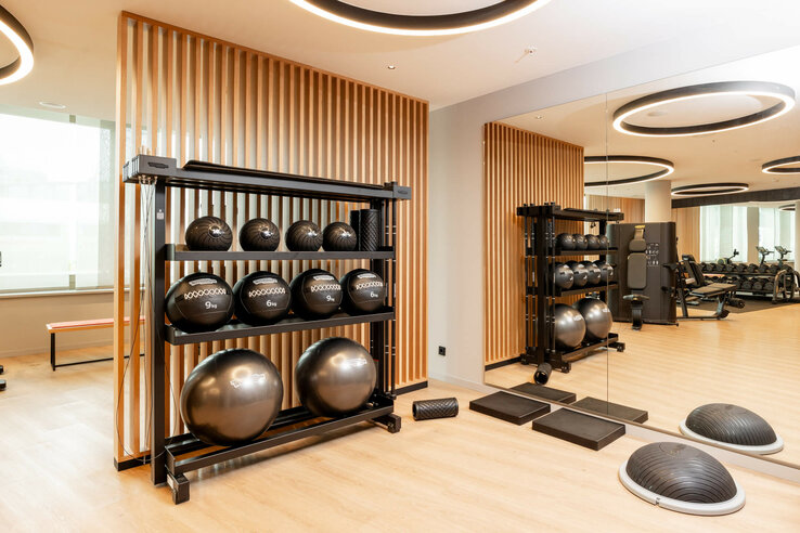Modern fitness room at the ATLANTIC Hotel Heidelberg with medicine balls, mirror wall and training equipment.