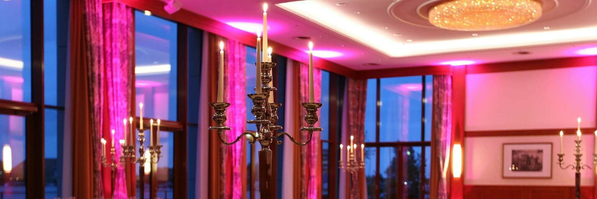 Elegantes Restaurant mit festlich gedeckten Tischen, Kerzenleuchtern und sanfter Beleuchtung im ATLANTIC Hotel Wilhelmshaven.