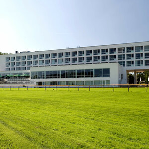 ATLANTIC Hotel Galopprennbahn: Modern building with large windows, surrounded by green lawns.