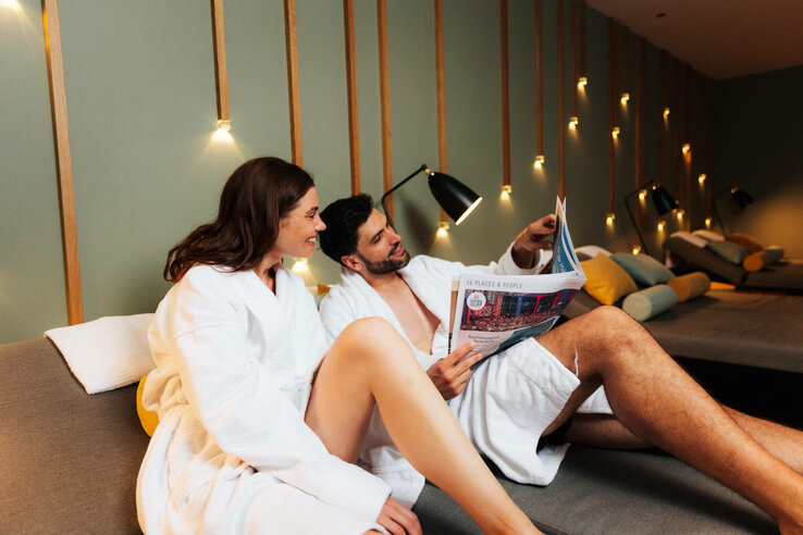 Paar in Bademänteln entspannt im Spa-Bereich des ATLANTIC Hotel Heidelberg.