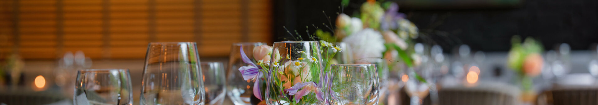 Nahaufnahme von Wein- und Wassergläsern im festlich geschmückten Wintergarten