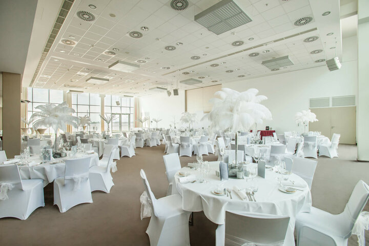 Eleganter Veranstaltungsraum mit runden, weiß gedeckten Tischen und großen Fenstern im ATLANTIC Hotel Sail City.