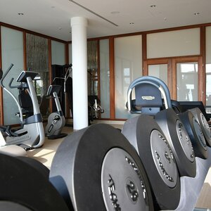 Fitnessgeräte im ATLANTIC Hotel Wilhelmshaven Moderner Fitnessraum mit Laufbändern, Hanteln und Fitnessgeräten in heller, einladender Umgebung.
