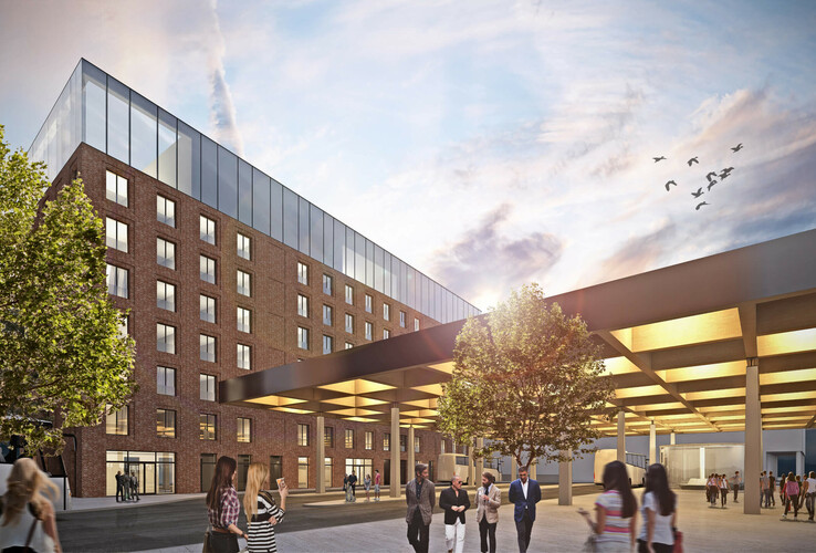 uniq by ATLANTIC Hotels in Kiel Modernes Hotel mit Glasfassade, Menschen im Eingangsbereich, Bäume und Himmel mit Vögeln im Hintergrund.