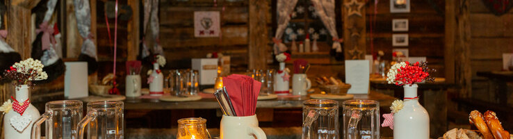 Gemütlicher, rustikaler Raum im ATLANTIC Grand Hotel Bremen, dekoriert mit karierten Lampions und gedeckten Tischen.