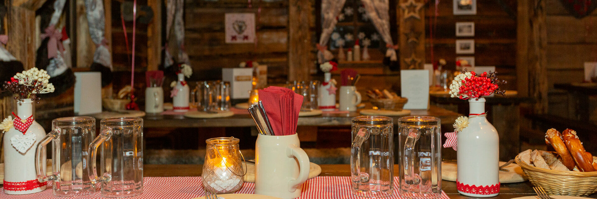 Gemütlicher, rustikaler Raum im ATLANTIC Grand Hotel Bremen, dekoriert mit karierten Lampions und gedeckten Tischen.