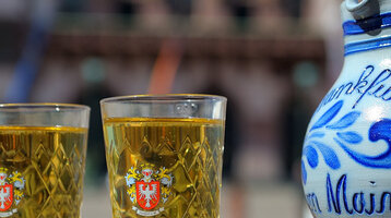Traditional Frankfurt cider and a vase in front of traditional half-timbered houses.