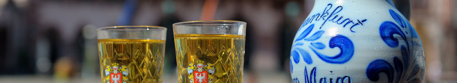 Traditional Frankfurt cider and a vase in front of traditional half-timbered houses.