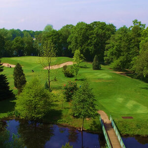 Golfplatz im Oberneuland | ATLANTIC Hotel Landgut Horn Golfplatz mit grünen Fairways, Sandbunkern, Bäumen und einem kleinen Teich im Vordergrund.
