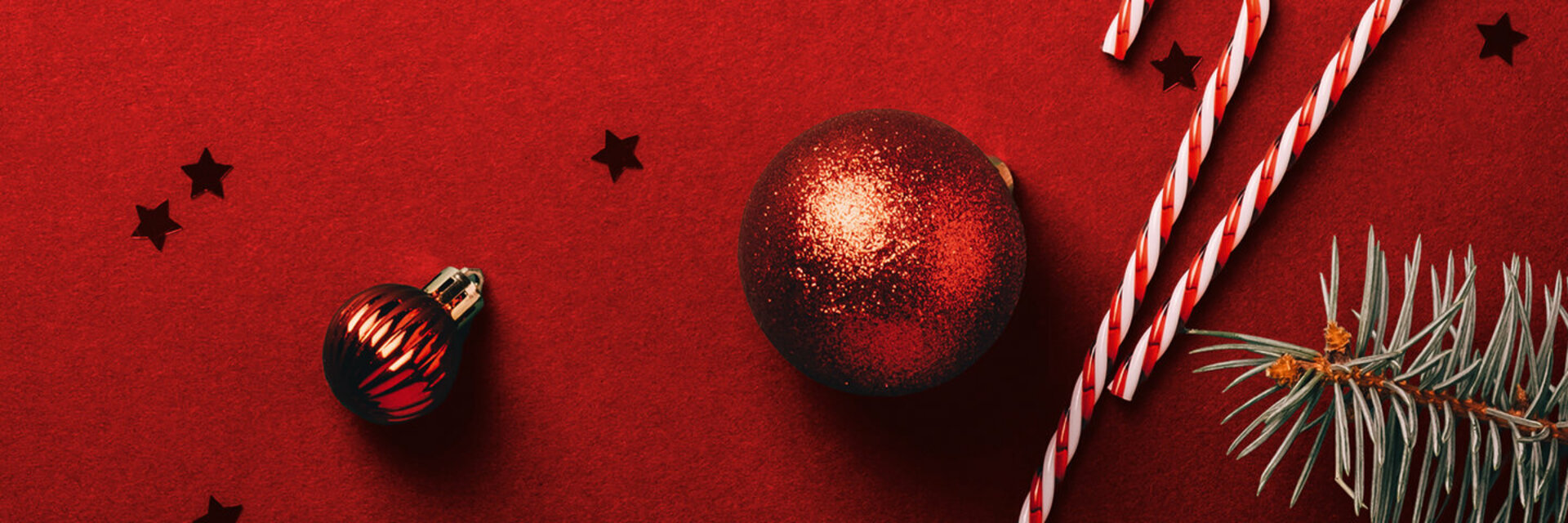 Weihnachtlicher Hintergrund mit Christbaumkugeln, Zuckerstange und Tannenzweigen