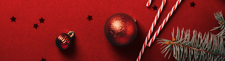 Weihnachtlicher Hintergrund mit Christbaumkugeln, Zuckerstange und Tannenzweigen