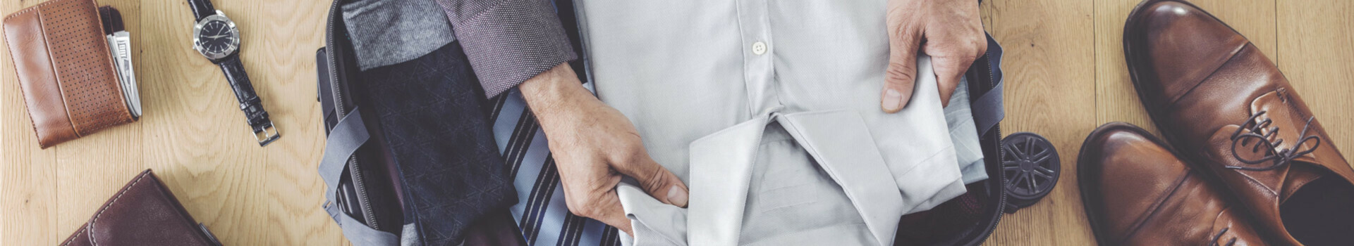 Noch etwas vergessen? Gepackter Koffer mit Hemd, Krawatten, Schuhen, Uhr und Brieftasche auf Holzboden im ATLANTIC Grand Hotel Bremen.