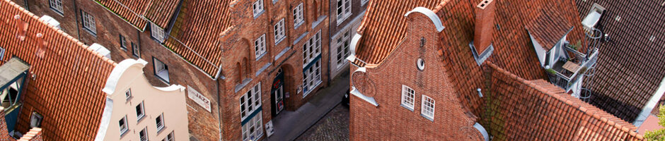 Aerial view of historic brick houses with red tiled roofs in Lübeck's old town.