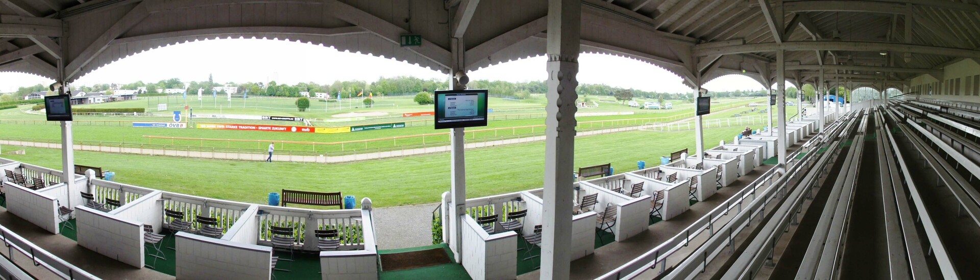 Überdachte Tribüne mit Blick auf die grüne Galopprennbahn des ATLANTIC Hotels in Bremen.