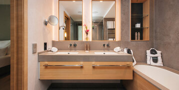 Doppeltes Waschbecken und Spiegel mit indirekter Beleuchtung im modernen Badezimmer