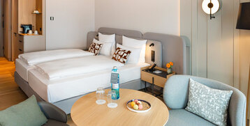 Blick auf Bett und die Sitzecke im Superior Doppelzimmer.