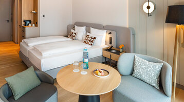 Blick auf Bett und die Sitzecke im Superior Doppelzimmer.