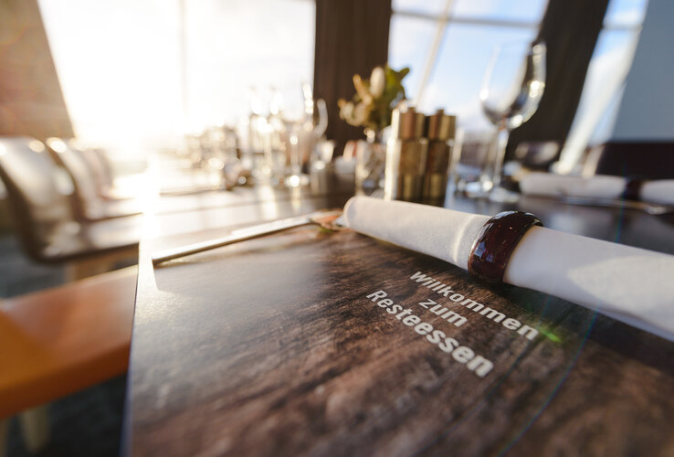 Elegant restaurant table at the ATLANTIC Hotel Sail City, Bremerhaven, with stylish table decoration at sunset.