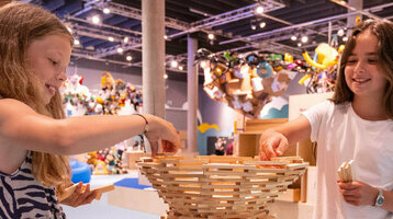 Zwei Mädchen bauen mit Holzklötzen im ATLANTIC Hotel Universum Bremen.