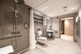 Modernes, barrierefreies Badezimmer im ATLANTIC Hotel Heidelberg mit Dusche, WC und Waschbecken.