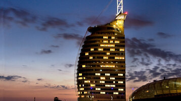Exterior View by night of ATLANTIC Hotel Sail City ATLANTIC Hotel Sail City at dusk, illuminated path and modern architecture against the evening sky in Bremerhaven.