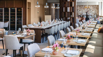 The 4FRANK restaurant, with a festive table setting and vases of flowers.