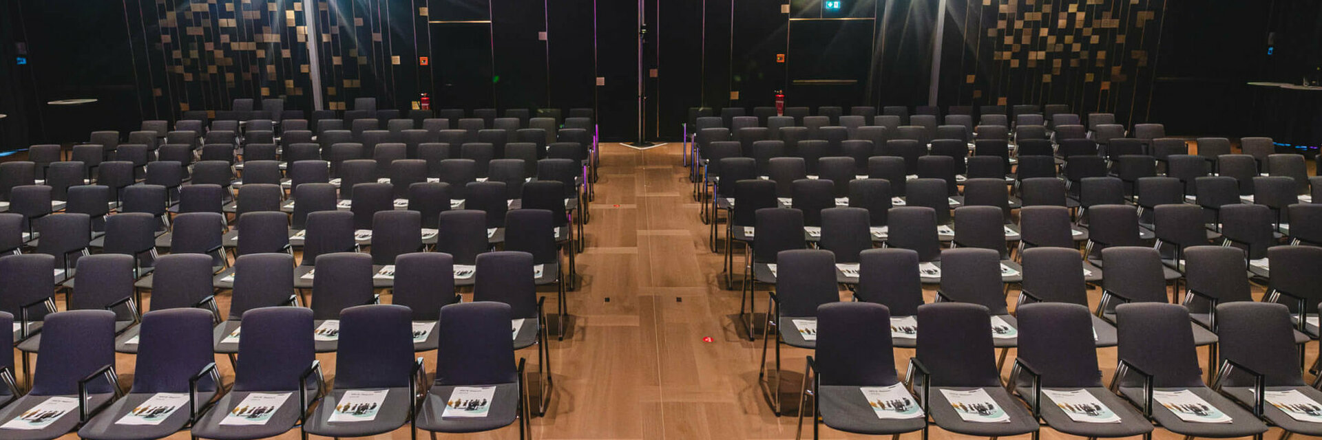 Moderner Konferenzraum im ATLANTIC Hotel Heidelberg mit vielen leeren Stuhlreihen, bereit für eine Veranstaltung.