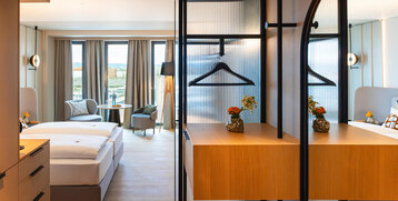 Blick ins Zimmer mit modernen Möbeln und Holzakzenten.