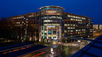 ATLANTIC Hotel Airport Bremen at night ATLANTIC Hotel Airport at night, modern building with illuminated windows and entrance area, blue sky.