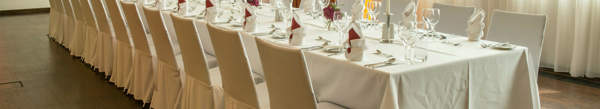 Festive table in function room Hörn in the ATLANTIC Hotel Kiel Elegant, festively decorated banquet at the ATLANTIC Hotel Kiel with long tables, white tablecloths and floral decorations.