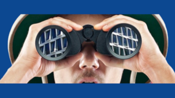 Ein Mann schaut durch ein Fernglas auf das ATLANTIC Hotel Münster, blauer Hintergrund