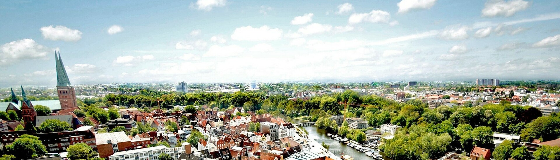 Overlooking Lübeck old town View of Lübeck's old town with red tiled roofs, church towers and river under a clear sky.