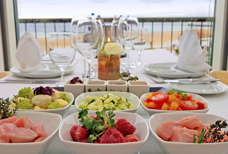Eleganter Tisch mit frischen Zutaten und Meerblick im ATLANTIC Grand Hotel Travemünde.