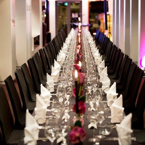 Festliche Tafel auf DECK 8 – die Bar Eleganter, langer Tisch im ATLANTIC Hotel Kiel, festlich gedeckt mit weißen Servietten, Gläsern und Kerzen.