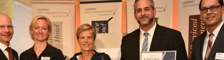 Geschäftsführer der ATLANTIC Hotels mit Zertifizierung des Star Awards in den Händen Eine Gruppe von fünf Menschen hält Zertifikate und Auszeichnungen in einem Konferenzraum.
