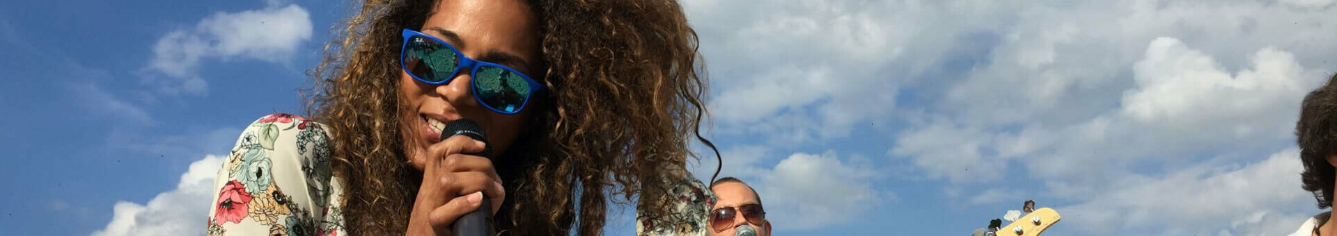 Eine Band spielt am Strand von Travemünde unter blauem Himmel.