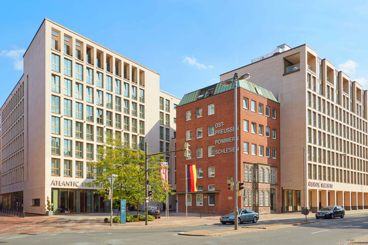 Moderne Hotelgebäude des ATLANTIC Grand Hotel Bremen an sonniger Straßenecke mit roten Backsteinelementen.