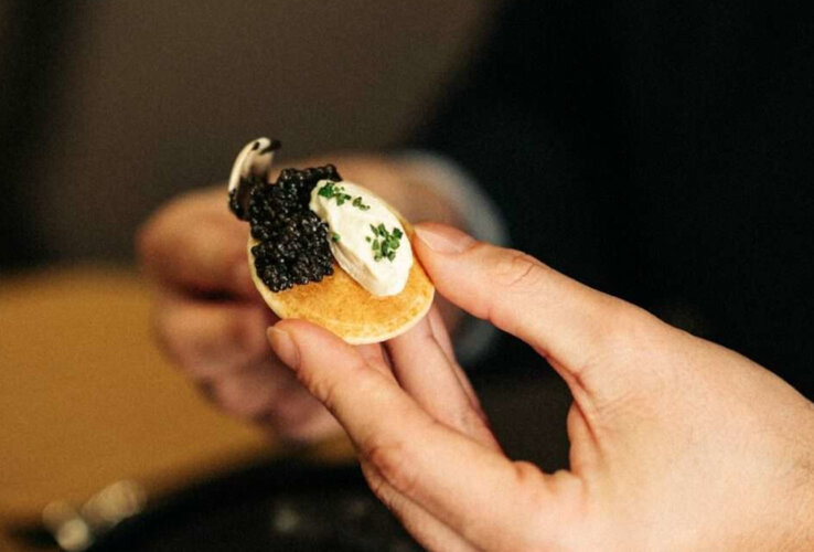 Ein kleiner Pfannkuchen mit Sauerrahm und Kaviar.